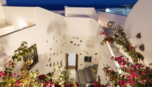 A modern interior with a staircase leading to a balcony.