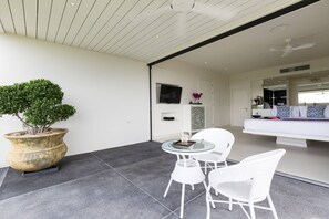 A modern living room with a large potted plant, a glass table, and white chairs. - DANISA-4BR-PLAILAEM (Ko Samui)