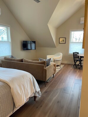 A bedroom with a large bed, a sofa, a TV, and a dining area with a table and chairs. - Newly Constructed Cozy 1-bedroom studio in Congress Park, Denver (Denver)