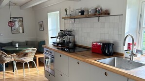 Ett modernt kök med en bänkskiva i trä, vita skåp och en inbyggd ugn.