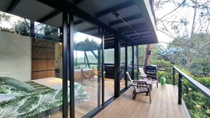 A modern outdoor deck with a glass enclosure, wooden flooring, and seating area. - Room-tranquil Holiday Park Retreat in Gu (Guarne)