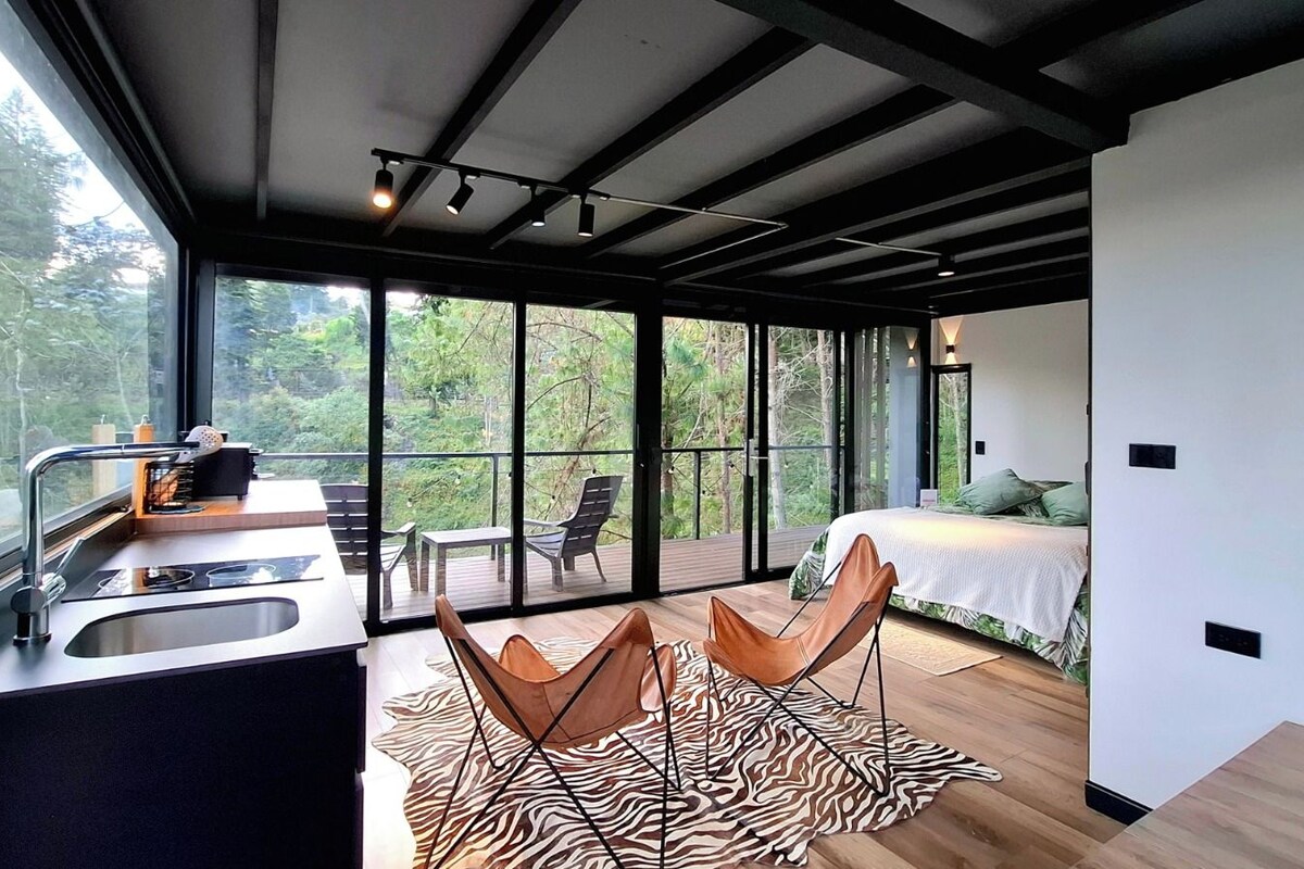 A modern interior with a kitchen, dining area, and bedroom.