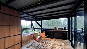 A modern kitchen with a large window, a wooden bench, and a zebra-patterned rug. - Room-tranquil Holiday Park Retreat in Gu (Guarne)