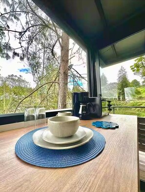 A modern dining area with a wooden table, a white bowl, and a coffee machine. - Room-tranquil Holiday Park Retreat in Gu (Guarne)