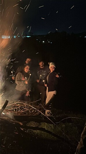 A group of people around a campfire at night. - Cabin in Guarne Nature, Comfort, and Adventure (Guarne)