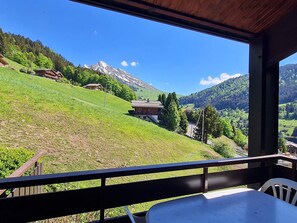 A balcony with a view of a mountainous landscape, a wooden table, and a chair. - Duplex for 6 with Wi-Fi and garage in La Clusaz (La Clusaz)