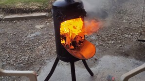 A wood stove emitting smoke, with a grassy area and trees in the background. - Tranquil Villa Retreat Near Medellin With Private Pool (Guarne)