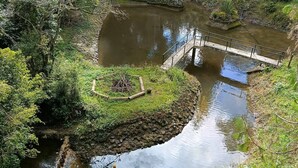A river with a small bridge and surrounding greenery. - Tranquil Villa Retreat Near Medellin With Private Pool (Guarne)
