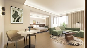 Una habitación de hotel moderna con cama, sofá verde, sillón y una mesa redonda.