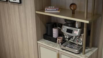 A coffee machine on a countertop with a coffee grinder and a mug.