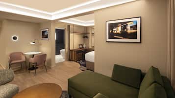 Una habitación de hotel moderna con un sofá verde, una pequeña mesa redonda, un escritorio con una silla, un espejo circular y un cuadro enmarcado en la pared.
