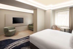 A hotel room with a bed, a flat-screen TV, a green sofa, a chair, a small round table, and a window with curtains. - Radisson Blu Medlock Hotel, Manchester (Manchester)