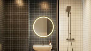 A modern bathroom with a toilet, sink, and shower.