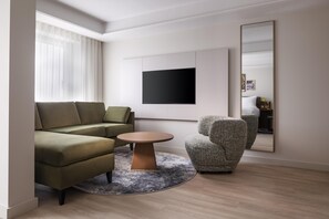 A modern living room with a sectional sofa, a round coffee table, and a patterned armchair. - Radisson Blu Medlock Hotel, Manchester (Manchester)