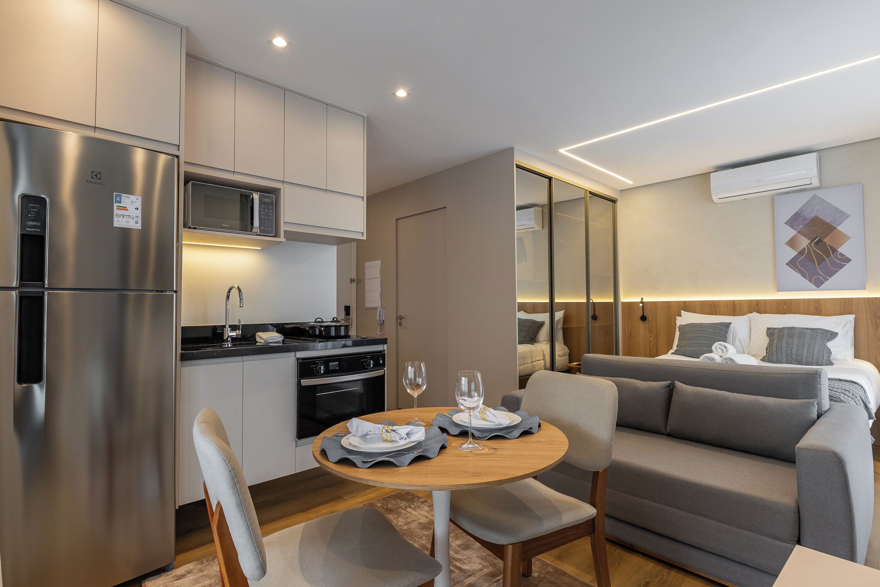 Una kitchenette compacta equipada con refrigerador, microondas y estufa.
