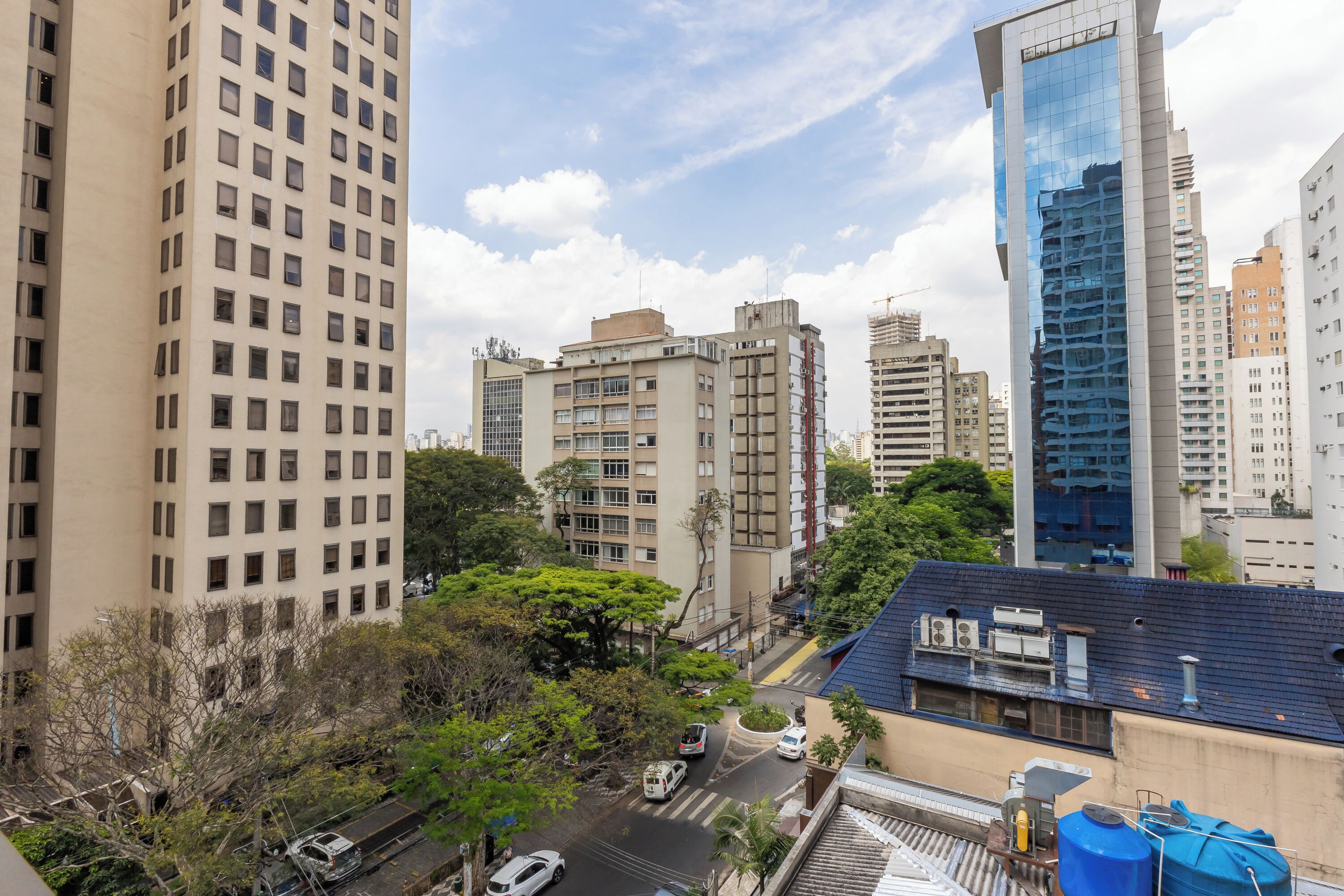 Un paisaje urbano con rascacielos, cielo despejado y una calle con vehículos.