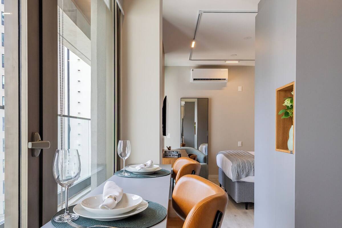 Une chambre d’hôtel moderne comprenant un coin repas, un lit et une salle de bain.