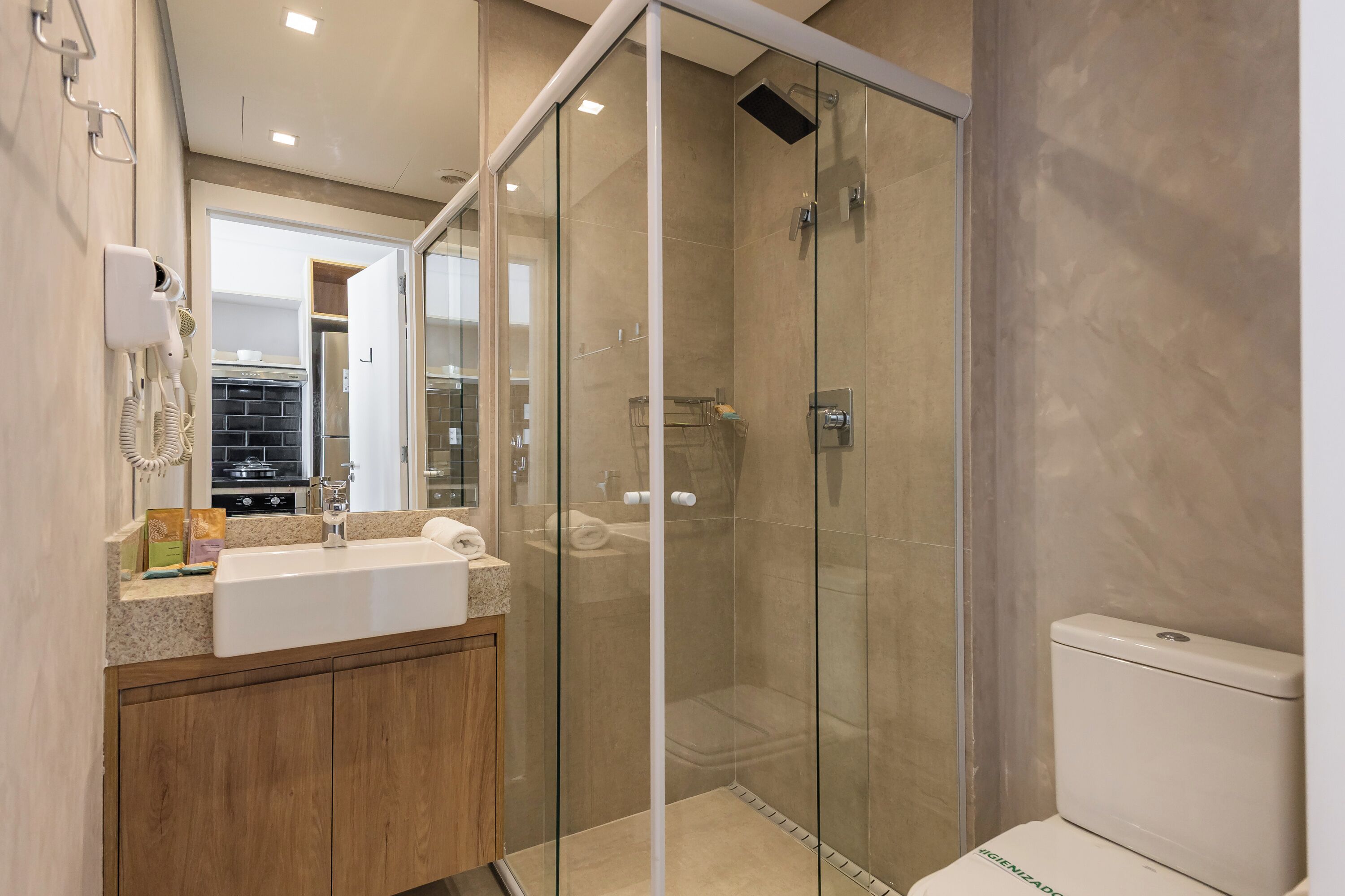 A modern bathroom with a glass-enclosed shower, a sink with a countertop, and a toilet.