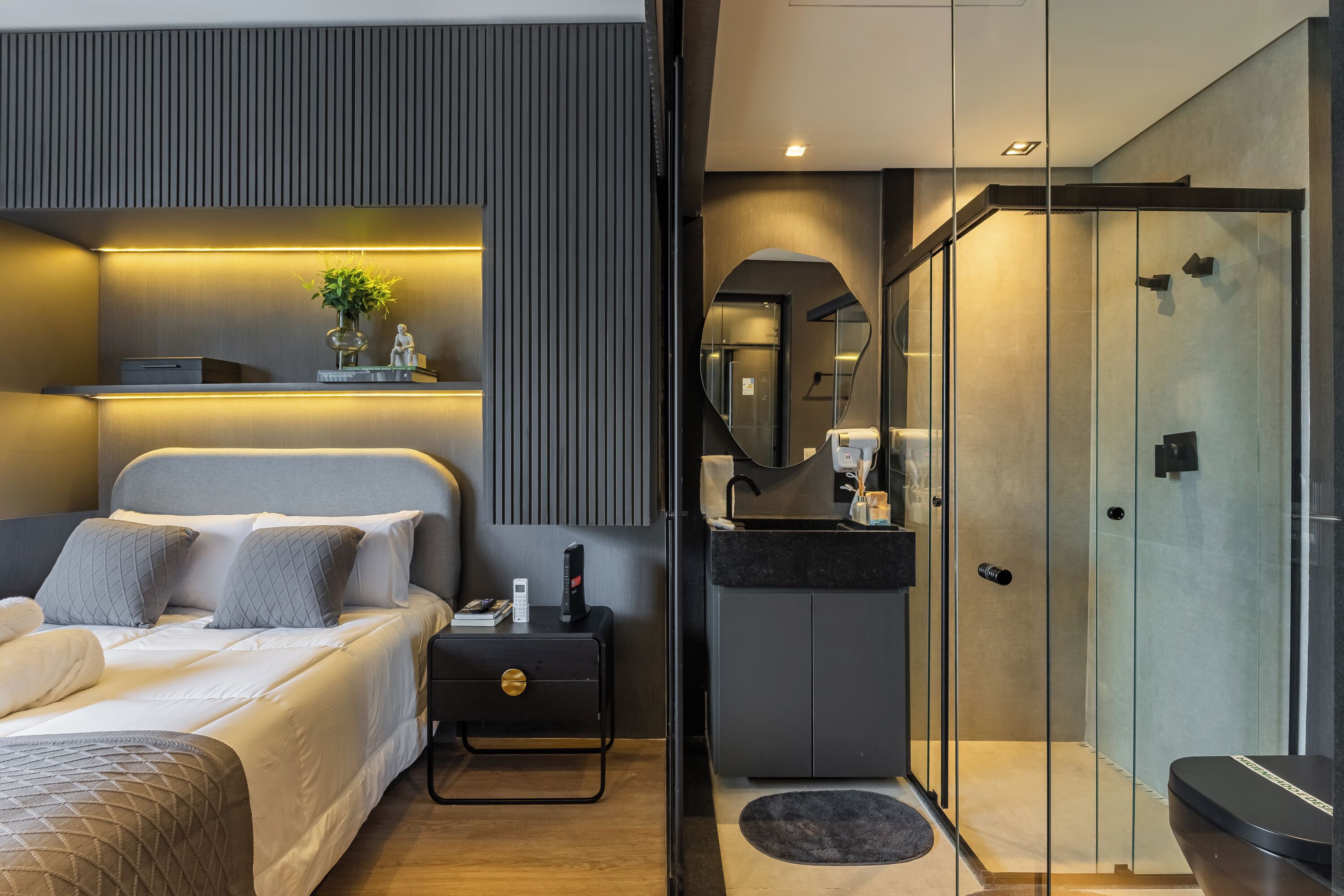 A modern bedroom with a bed, bedside table, and a nightstand.