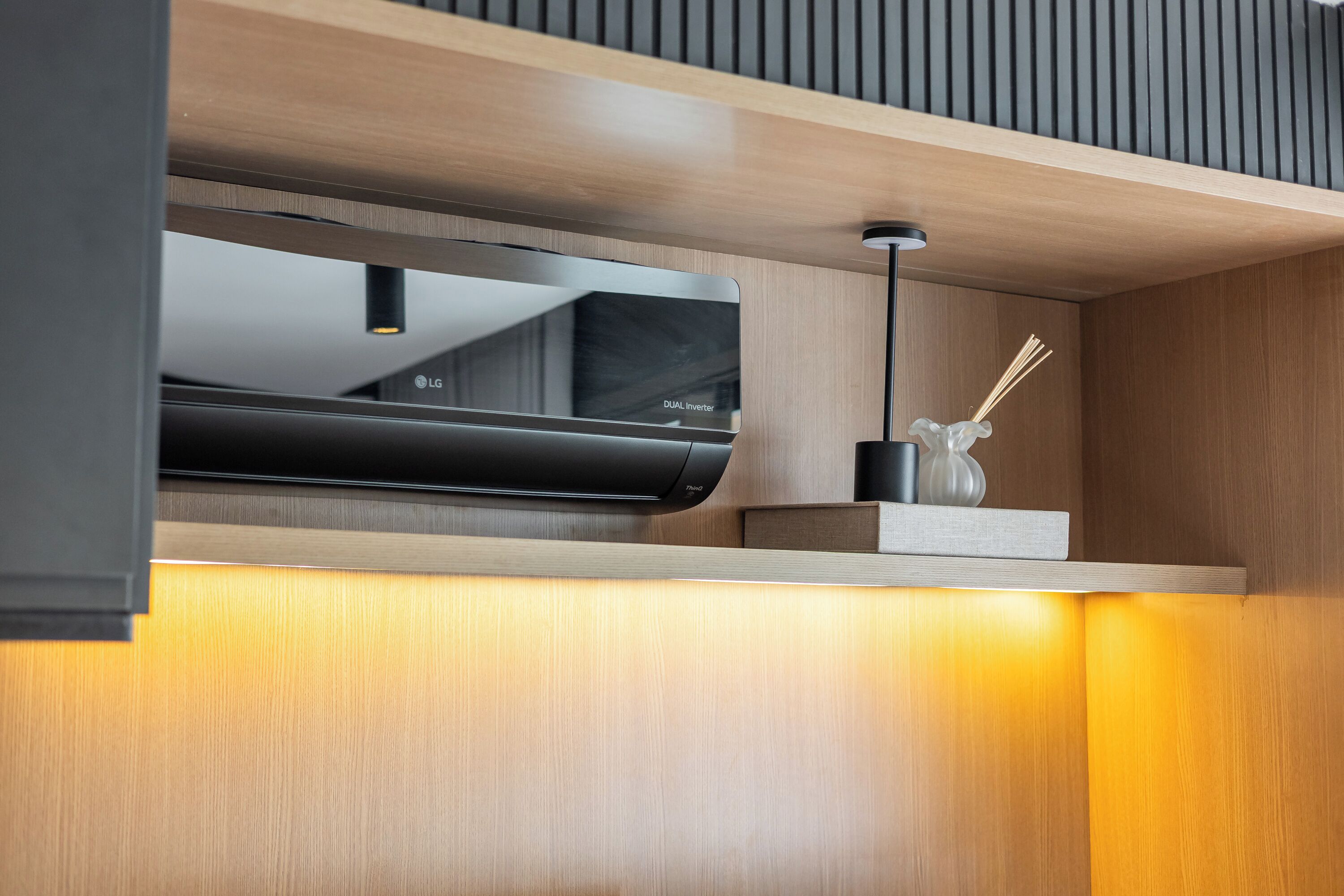 Una cocina moderna con un extractor LG Dual Inverter integrado, encimera de madera y un diseño minimalista.