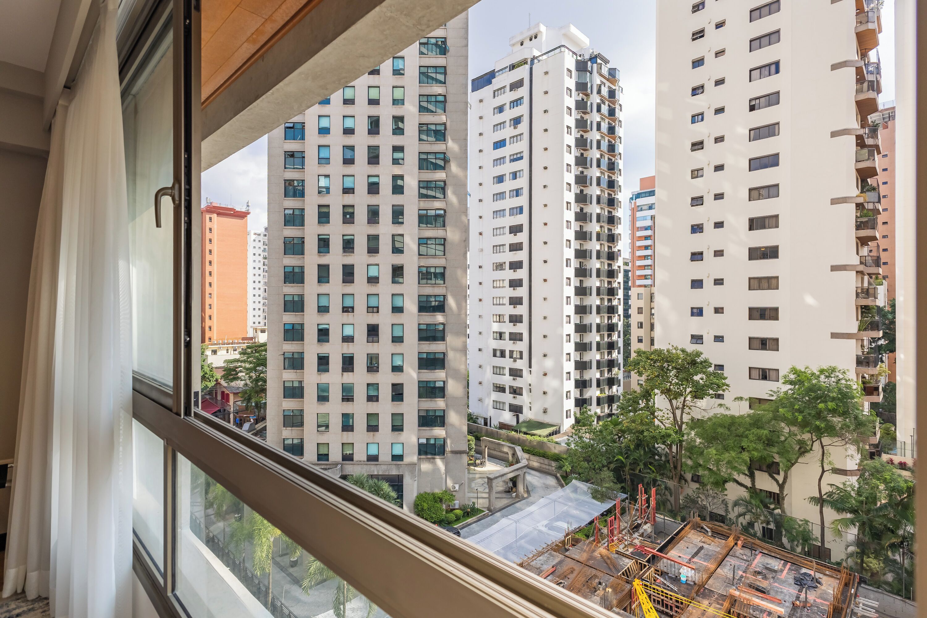 Un edificio de gran altura con varios pisos, ventanas amplias y vistas del área urbana circundante.