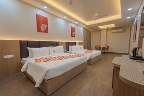 A hotel room with two beds, a desk, a chair, and a ceiling fan. - Mosaic Connect Ayodhya (Faizabad)