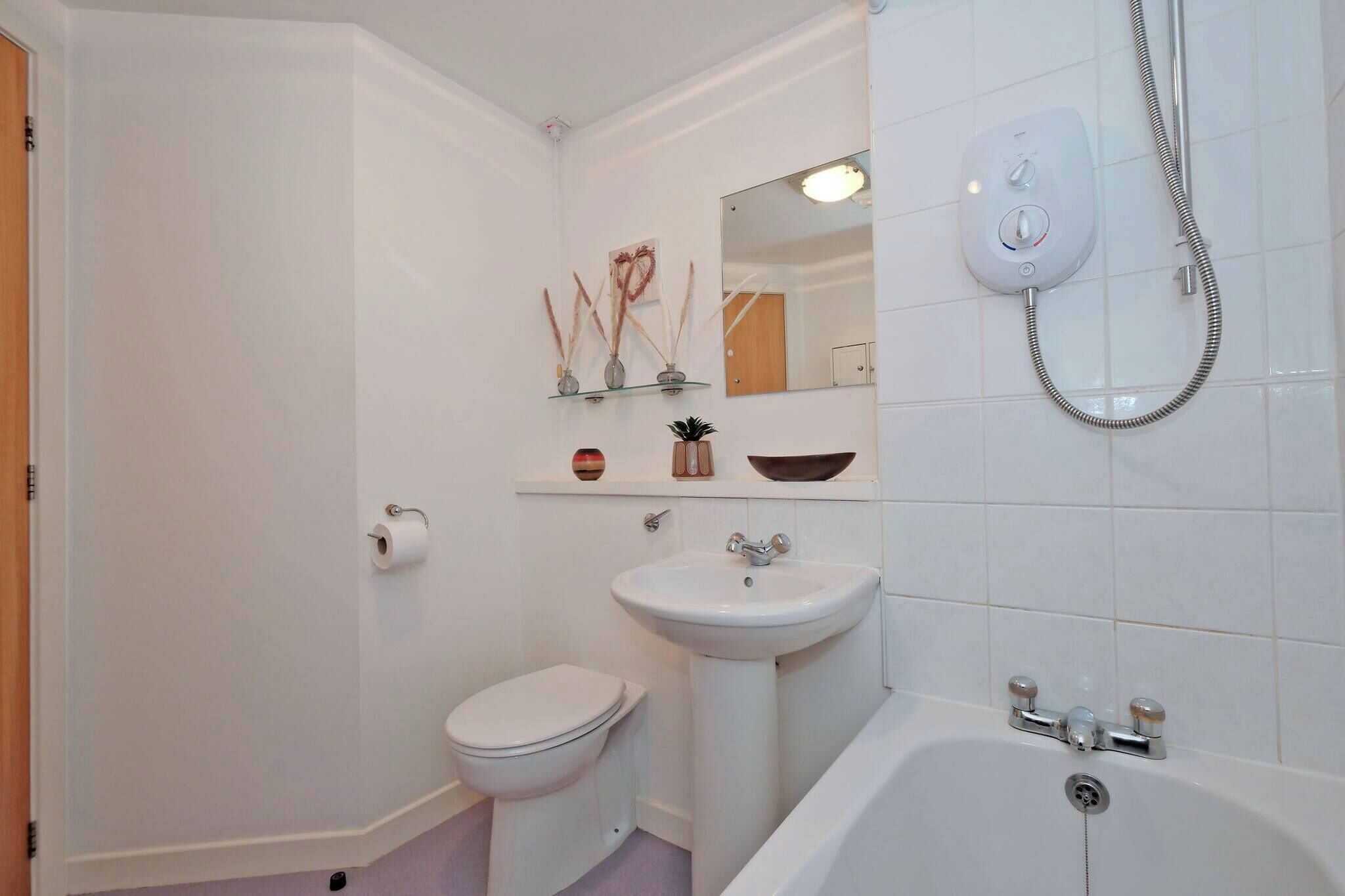 A bathroom with a toilet, sink, and bathtub.