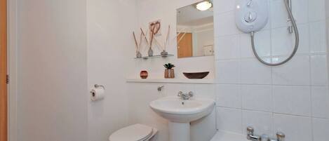 A bathroom with a toilet, sink, and bathtub.