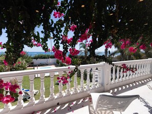 A balcony with a white balustrade overlooking a pool and a view of the sea. - Beachfront apartment with communal pool and parking in San Pedro de Alcántara (San Pedro Alcántara)
