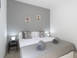 A bedroom with a bed, pillows, a bedside table, and wall art. - Modern and functional apartment in Malaga, near beaches (Málaga)