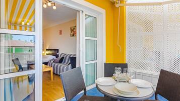 A dining area with wicker chairs and a round table set for four.