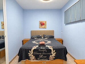 A bedroom with a bed, nightstands, a wall-mounted shelf, and a framed picture. - Beautiful 1-bedroom apartment in Costa Adeje, near beach (Costa Adeje)