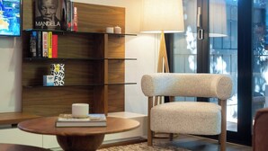 Un salon moderne avec une bibliothèque, une table ronde en bois et un fauteuil confortable.