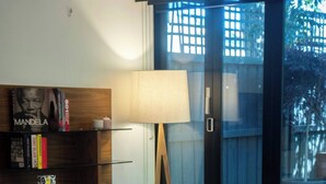 Un salon moderne avec un canapé, une table basse, une lampe et une bibliothèque.