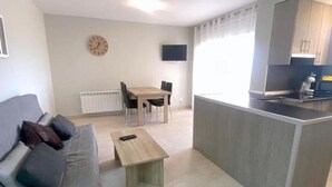 Ein modernes Wohnzimmer mit einer Couch, einem Couchtisch und einem Essbereich mit Stühlen.