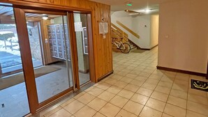 Ein Flur mit einer Holztür, einem Fahrrad und einer Treppe, die zu einer anderen Ebene führt.