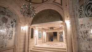 An ornate interior with a grand staircase, detailed wall carvings, and a chandelier. - seaview hotel (Alexandria)
