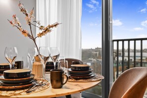 A dining table set with plates, glasses, and a vase with branches. - Comfortable & Peaceful 2BR Apartment Near King’s Cross (London)
