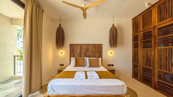 A spacious bedroom with a large bed, wooden headboard, and a ceiling fan.