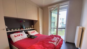 Un dormitorio con cama, ventana y radiador.