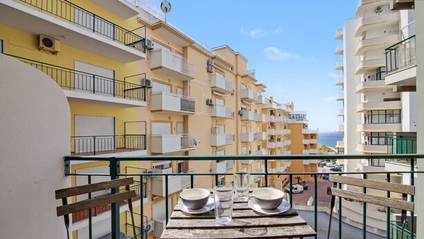 A balcony with a table, two bowls, and a glass. - Apartment 'Ocean Terrace 3 B - With Pool' with Swimming Pool and Balcony (Armação de Pêra)