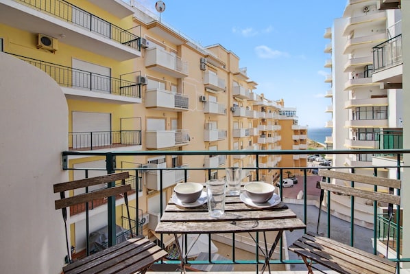 Ein Balkon mit Tisch, zwei Schalen und einem Glas.