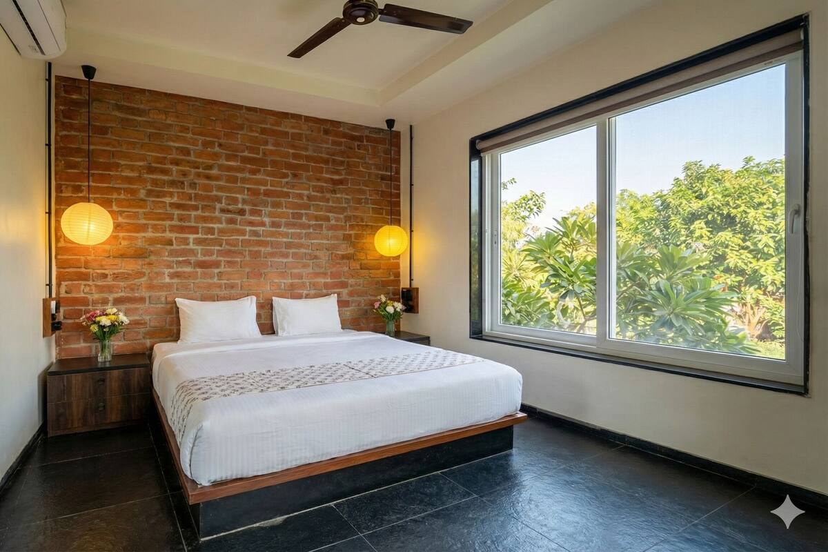 Ein modernes Schlafzimmer mit Backsteinwand, einem großen Fenster und einem Bett mit weißen Bettwäsche.