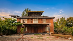 A two-story house with a balcony, a large wooden door, and a paved front yard. - Brick Villa Heritage  (Trimbak)