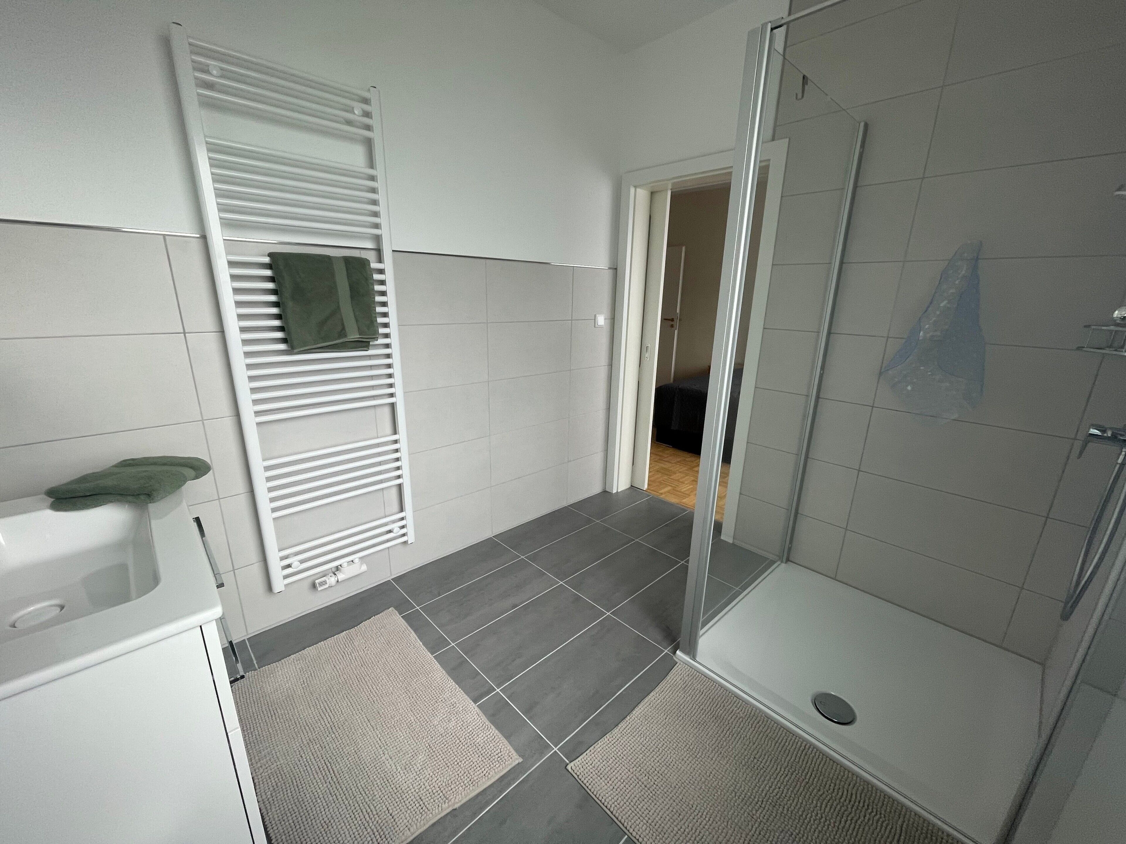 Un baño con ducha, toallero y retrete.