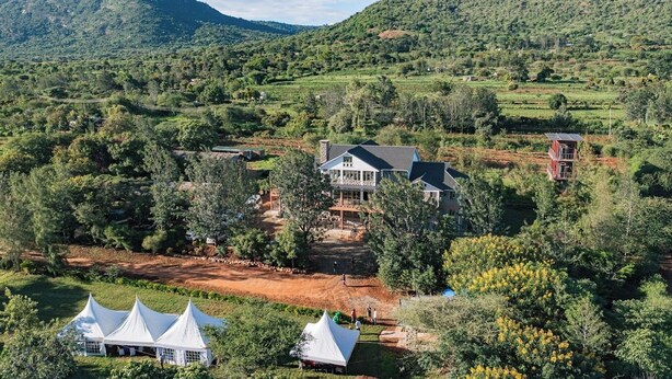 A large house surrounded by lush greenery and hills. - Casa Kalimbini Resort (Sultan Hamud)