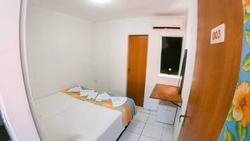 Una habitación con cama, escritorio, silla y ventana.