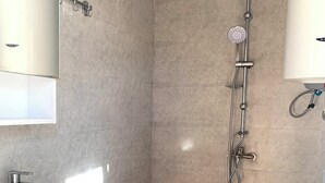 A bathroom with a shower, sink, and toilet.