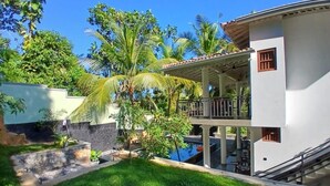 A two-story building with a balcony, a swimming pool, and lush greenery. - Unawatuna Heritage Villas (Unawatuna)