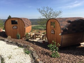Two wooden cabins labeled "Villa Frodo" and "Villa Sam" with a picnic table and a view of the countryside. - Apart-Hotel Kastanienhof (Dannenfels)